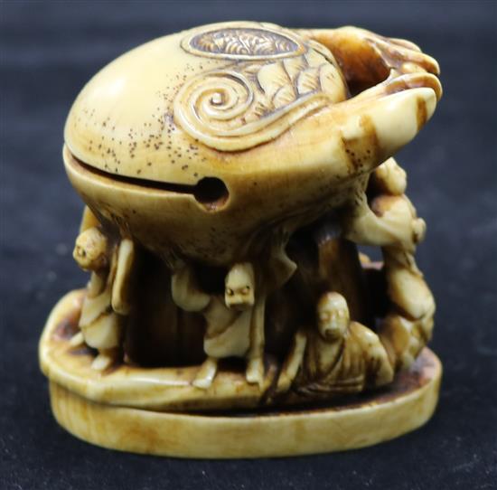 A carved ivory of figures under a crab